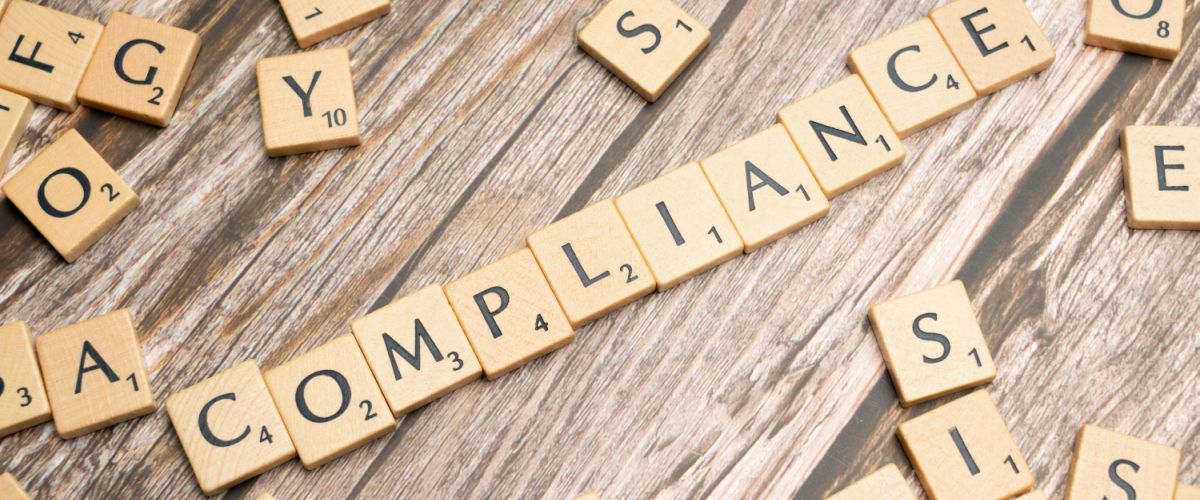 image of the word compliance made with scrabble pieces